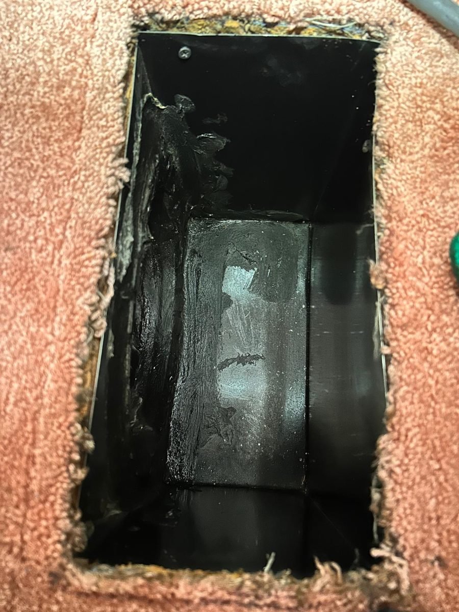 Floor vent opening with dark buildup on the duct walls