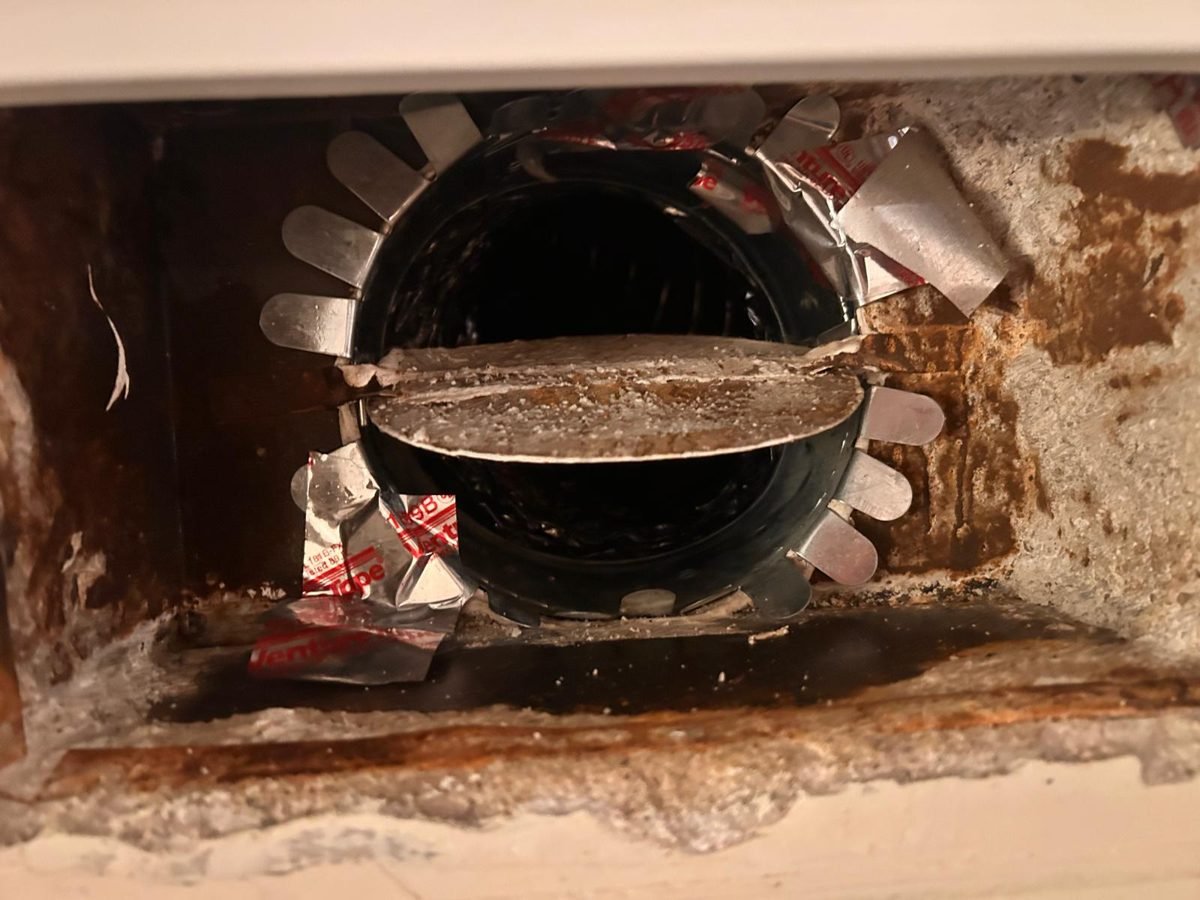New round duct collar fitted inside a vent boot and sealed with foil duct tape